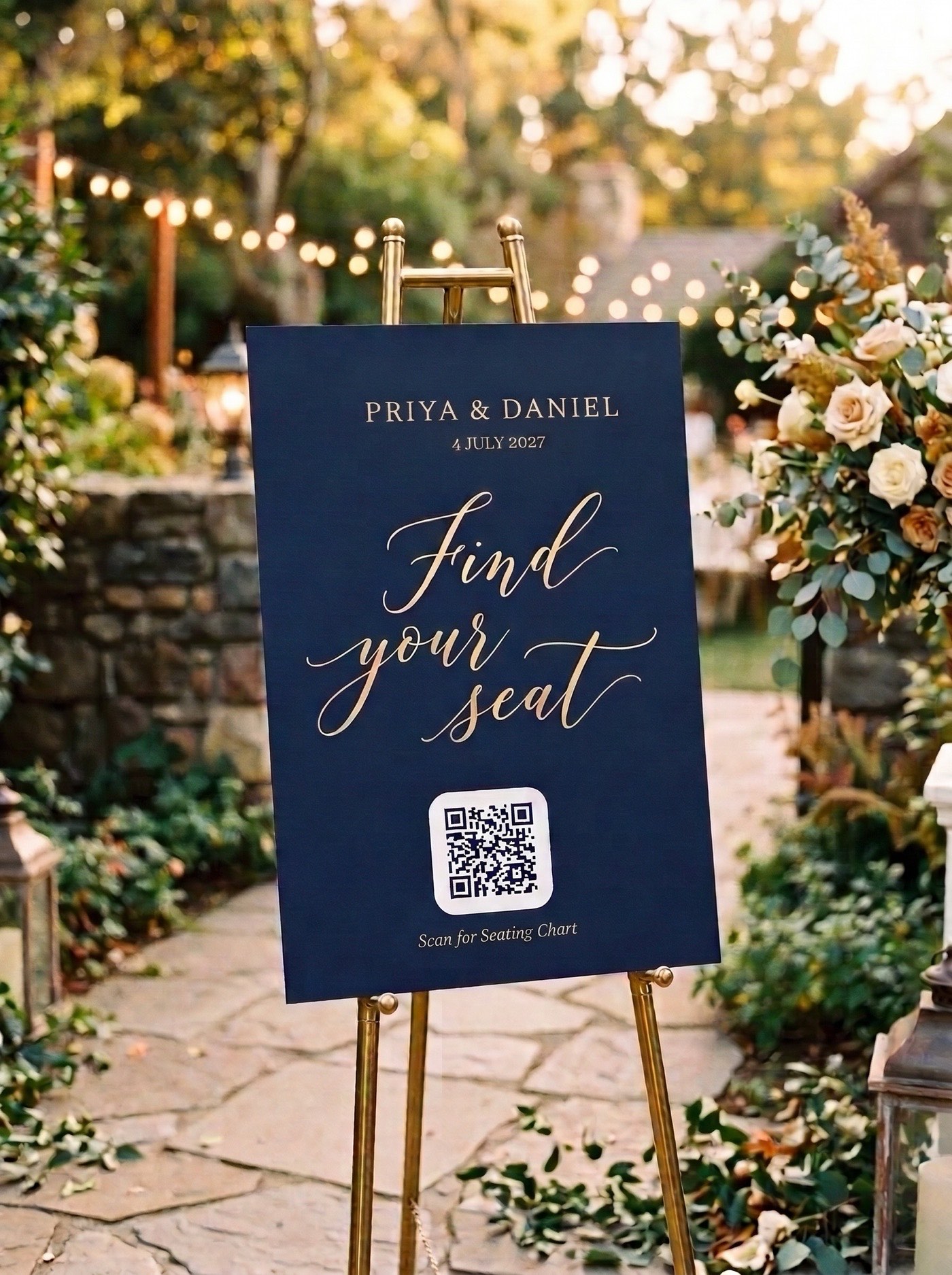 A navy welcome sign on a brass easel at a garden venue, reading Find your seat with a QR code